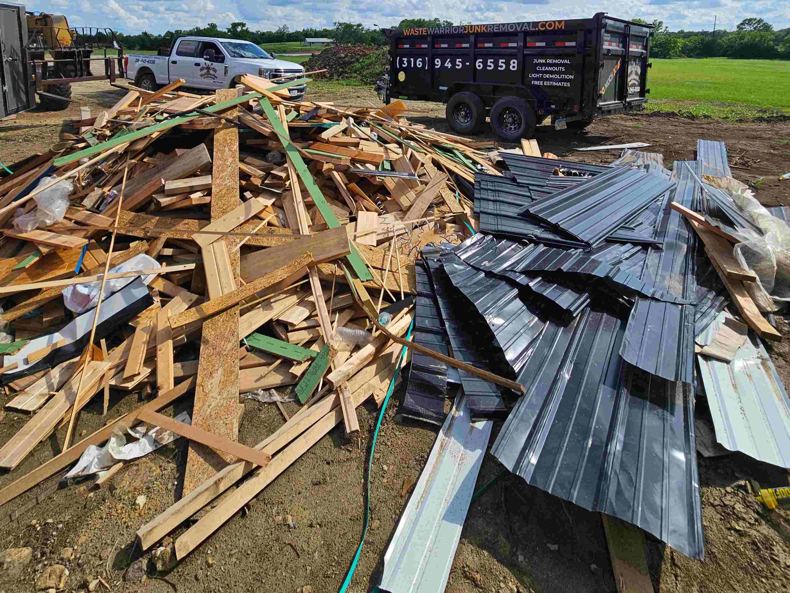 A pile of furniture and boxes sits on the grass before removal