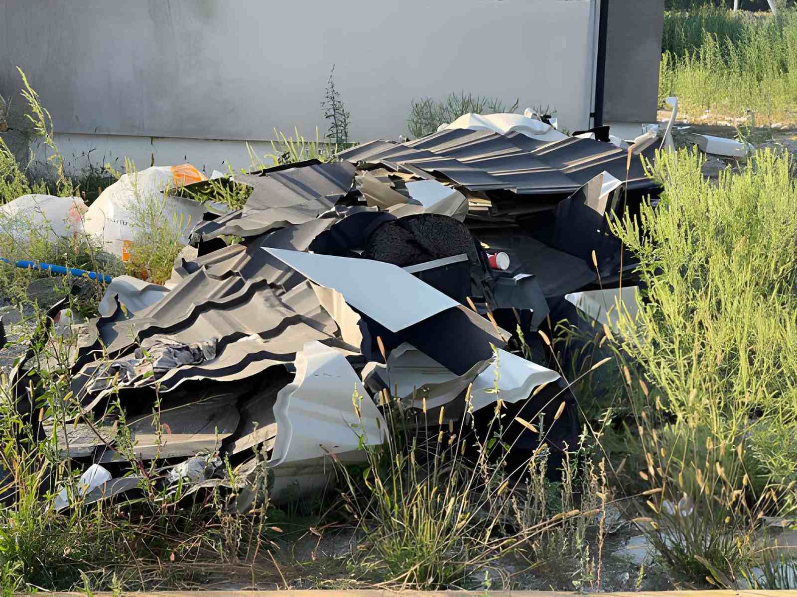 A pile of debris, including metal and plastic, is scattered