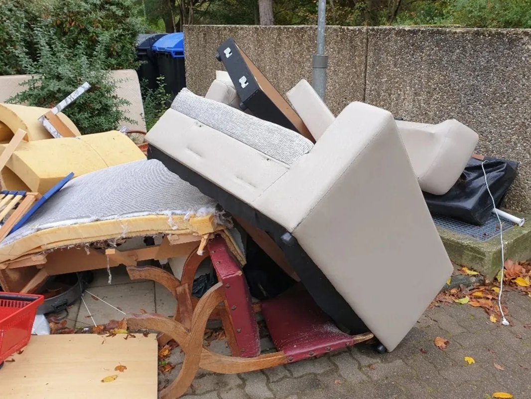 A pile of discarded furniture and household items sits